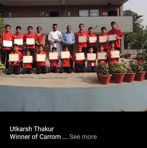 School carrom tournament winners holding certificates